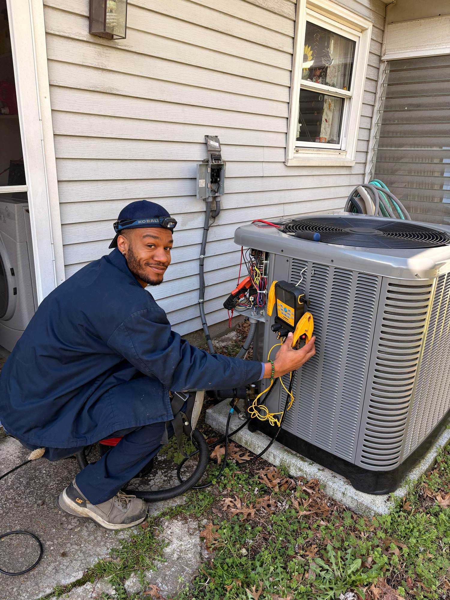 A technician providing AC repair for a service call in the Hampton, VA area.